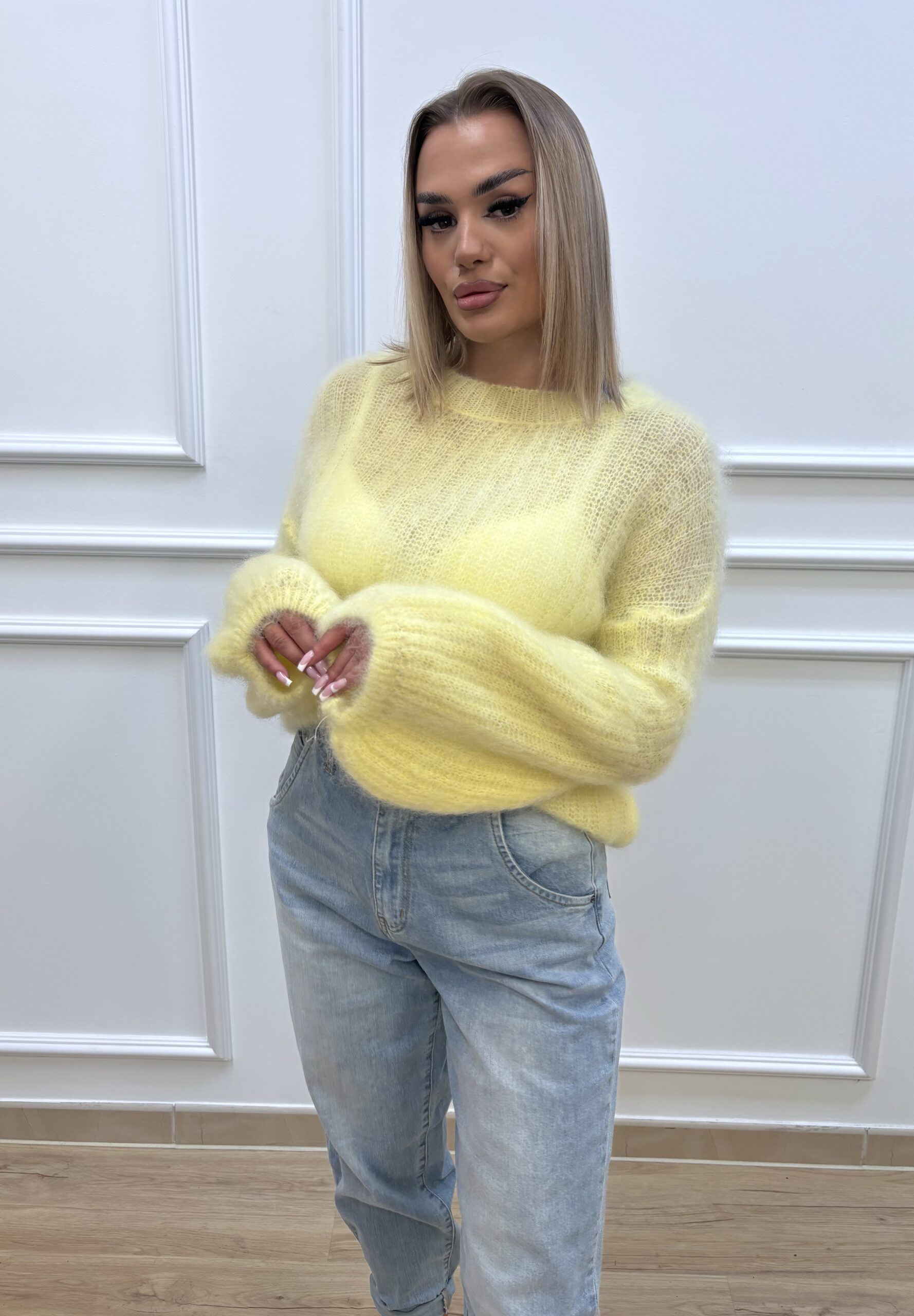 Modelka w zoltym swetrze moherowym z szerokimi rekawami, noszaca jasne dzinsy – kolekcja Secret Line